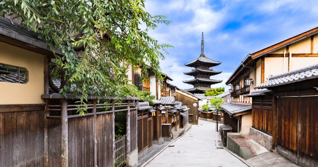 A scenic view of Kyoto’s traditional townscape with a historic temple and old-fashioned streets, reflecting the cultural heritage of Japan.