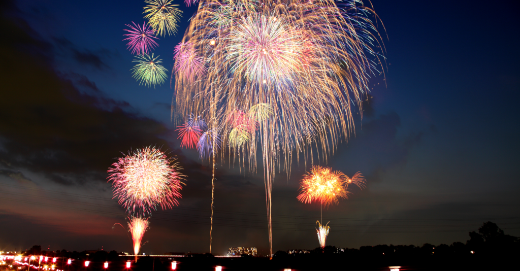 A vibrant fireworks display lighting up the night sky during a summer festival in Japan