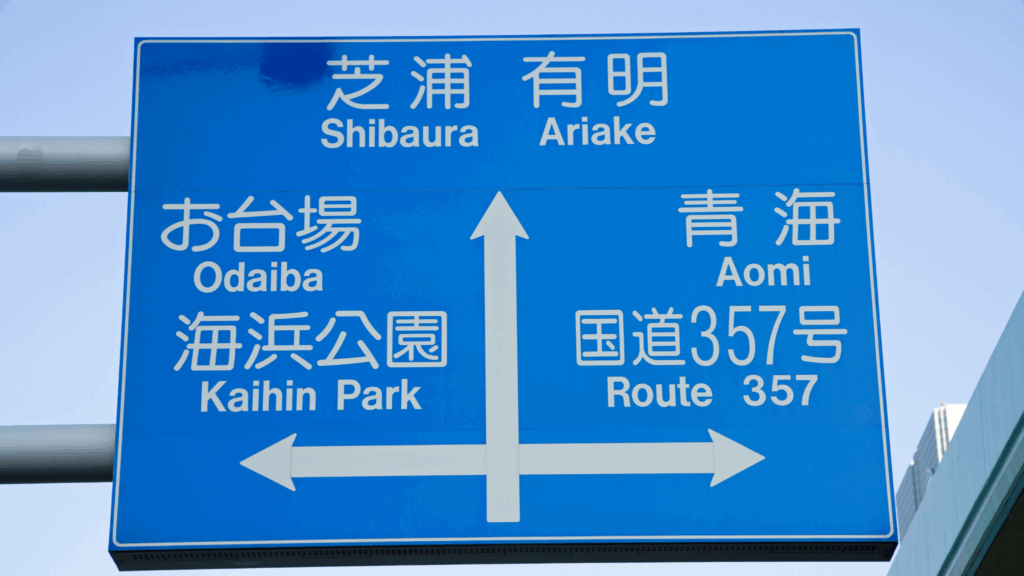 Road signs in Japan showing directions in both Japanese and English for easier driving and navigation.